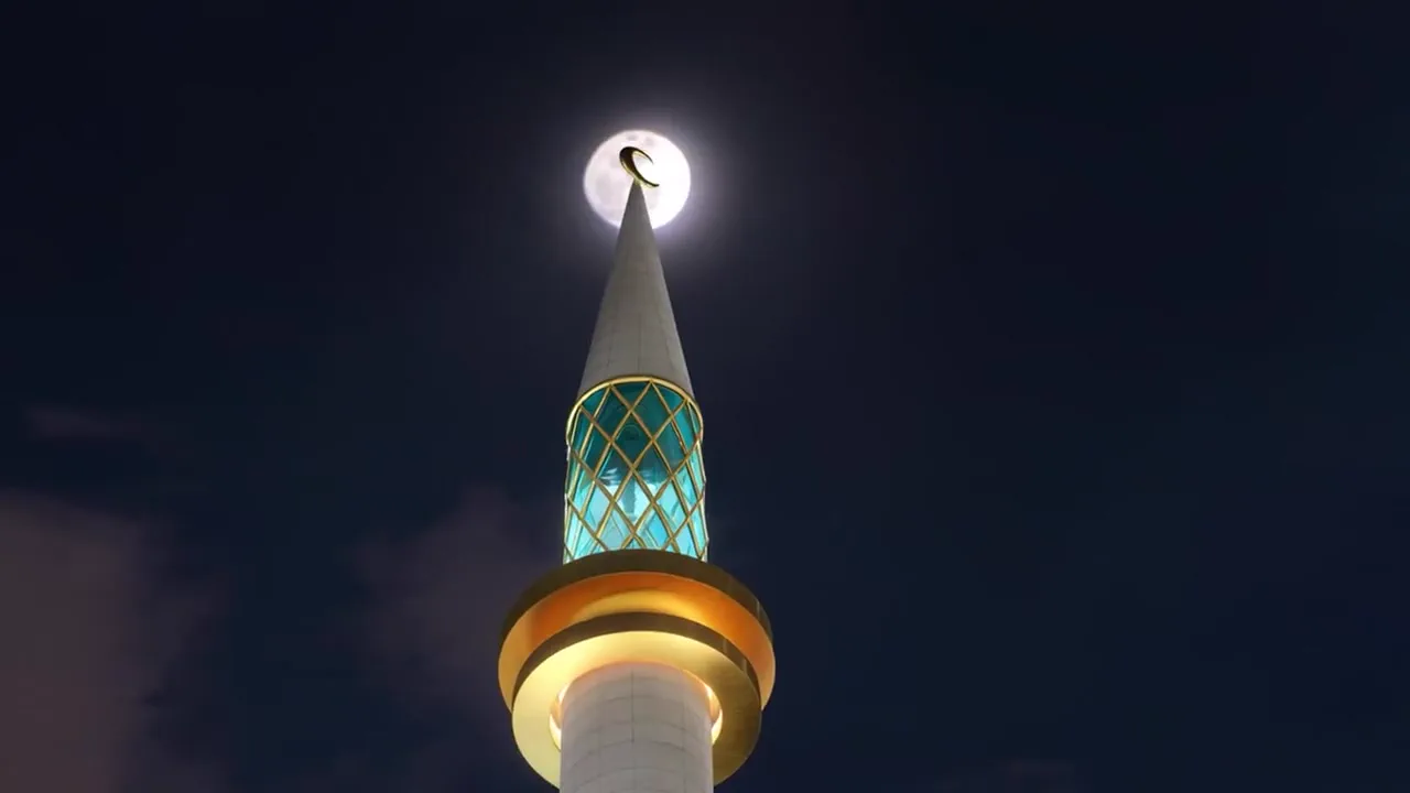 Das Minarett, türkis und gold beleuchtet